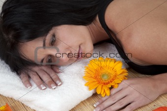 Woman lying on bamboo mat at spa