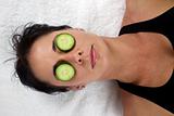 Woman with cucumber slices on her eyes