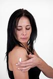Woman applying moisturizing cream to her arm