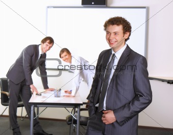 Portrait of business man with team mates discussing in the background