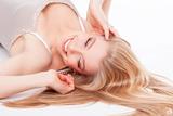 beautiful young woman lying down, eyes closed, smiling - isolated on white