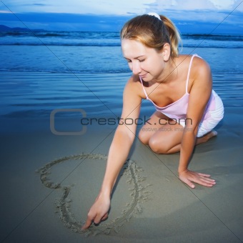 Young woman draws heart