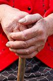 Old woman hands leans on walking stick