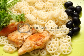 Round pasta with fried checken, parsley and olives