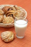 Glass with fresh milk and puff pastry on bamboo place mat