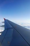 Aircraft wing. High-altitude flight on blue skies.