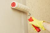 Hand in glothes lubricating wall on glue for wallpaper