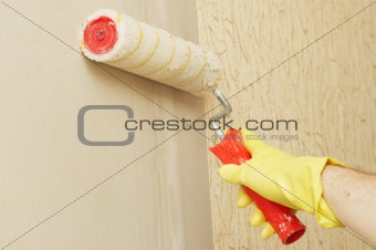 Hand in glothes lubricating wall on glue for wallpaper
