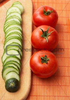 Red-ripe tomatoes and slices of cucumber