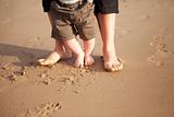 Mother and baby walking on beach