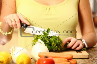 Young wife cutting parsley