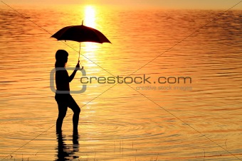 silhouette of young woman against summer sunset 