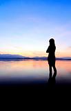 Silhouette of a girl in the water at sunset
