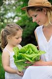 Young mother and daughter with lettuce
