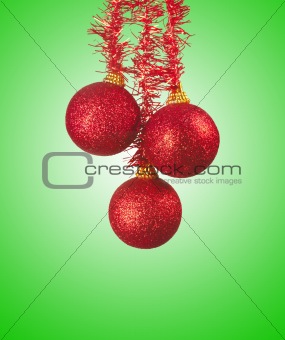 Red christmas-tree decoration balls over green background
