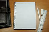 White Blank Notebook with white pencil and rubber on Wood Background