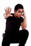 young latin man, pensive, with his hand in stop signal, isolated on white background, studio shot