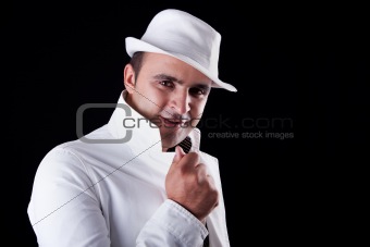 smiling man with his white hat and coat, isolated on black. Studio shot