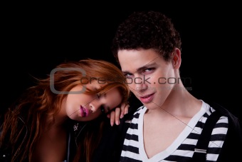handsome young couple, she with her head on his shoulder, isolated on black, studio shot