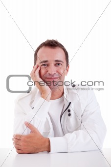smiling middle-age man sitting at desk on a black background. Studio shot