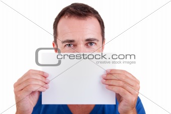 Man holding a white card in front of face, looking to camera, isolated on a white background. Studio shot.