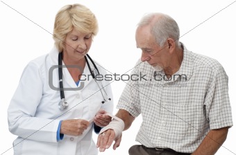 Doctor bandaging old man's wrist