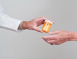 Pharmacist or doctor passing pills to patient