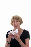 Senior woman sneezing into handkerchief