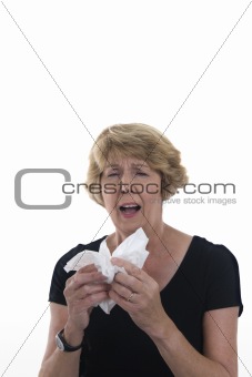 Senior woman sneezing into handkerchief