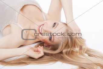 beautiful young woman lying down, eyes closed, smiling - isolated on white