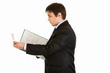 Serious modern businessman  holding folder with documents in  hand
