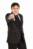 Smiling young businessman holding keys in  hand
