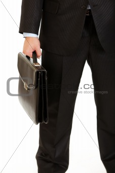 Businessman holding briefcase in hand. Close-up.
