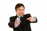 Smiling modern businessman pointing finger on calculator 
