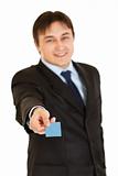 Smiling young businessman giving credit card
