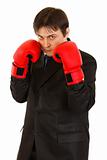 Confident young businessman with boxing gloves 

