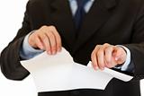 Businessman tearing sheet of white paper. Close-up.
