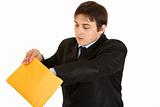 Interested young businessman checking parcel
