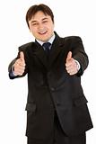Smiling young businessman showing  thumbs up gesture
