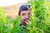 Young man in the bush of cannabis