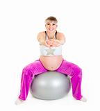 Smiling beautiful pregnant woman doing exercises on fitness ball
