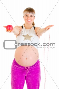 Smiling beautiful pregnant woman holding measure tape and  apple

