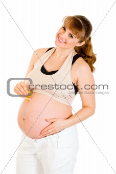 Smiling pregnant woman holding  baby dummy near belly
