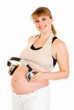 Smiling pregnant woman holding headphones on her belly
