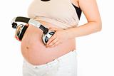 Pregnant woman with headphones on her belly.  Close-up.

