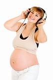 Happy pregnant woman listening music in headphones 
