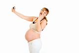 Laughing pregnant woman photographing herself
