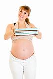 Smiling pregnant woman holding present for her baby 
