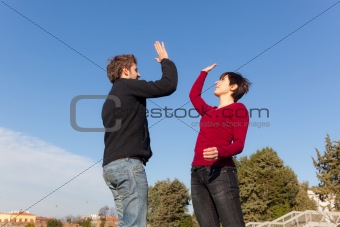 Young Man with Woman Jumping and Giving High Five