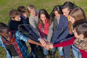Happy College Students with Hands on Stack
